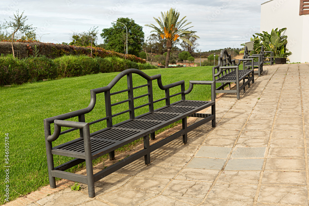 Obraz premium Paisaje de jardín con bancos de hierro.