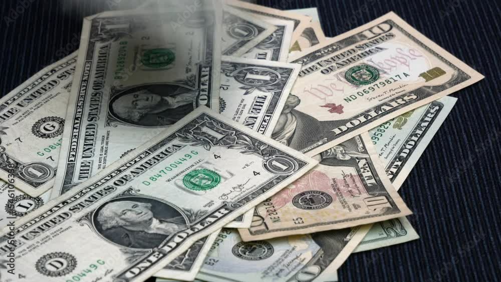 US Dollars being counted and falling on a table one by one. US Dollars being counted and falling on a table one by one.