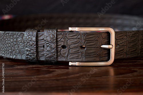 Leather trouser belt in the background . Men's  fashion accessories closet. Genuine leather, handmade belt  photo