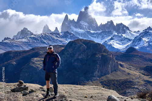 white man trekking in El Chalten, Patagonia Argentina. in the background you can see the Fitz Roy hill surrounded by clouds