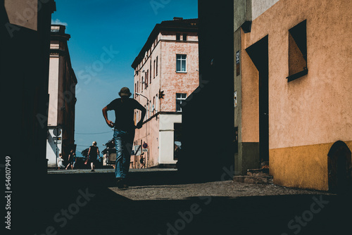 Fototapeta Naklejka Na Ścianę i Meble -  silhouette of the man on the street of small town, people on the streets