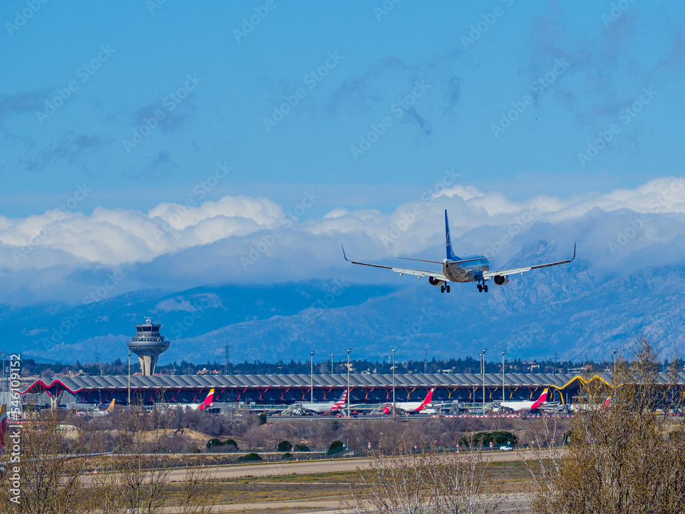 plane landing on the runway of Madrid airport, in front of the terminal 4 tower. plane landing on the runway of Madrid airport, in front of the terminal 4 tower.