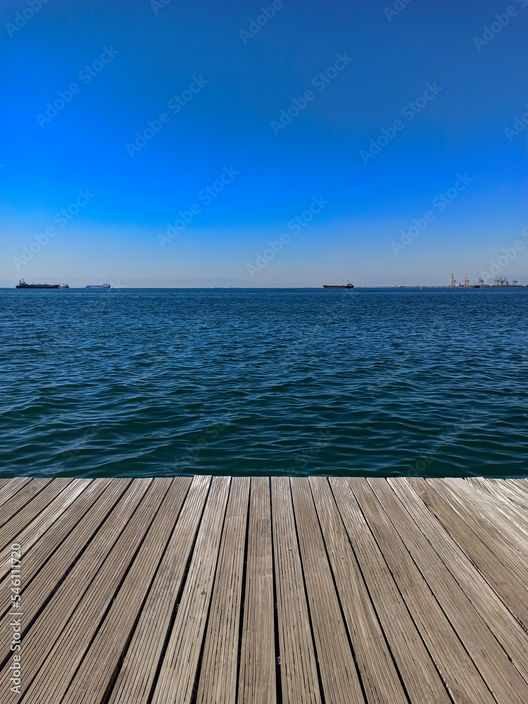 Wooden pier in Thessaloniki port of the Thermaikos gulf and sea and sky view in the background 