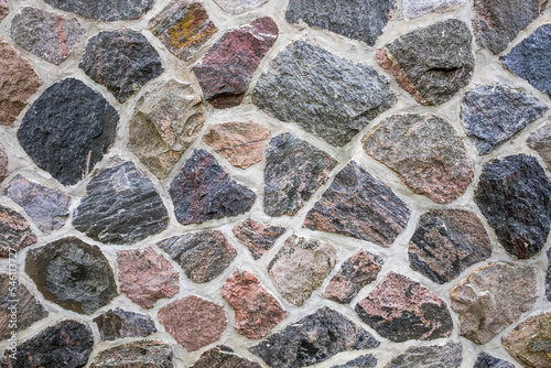 A multi colored textured granite wall in a random pattern.