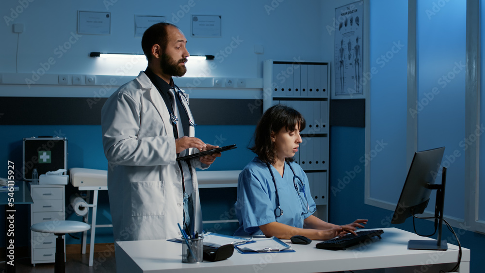 Medical staff analyzing patient illness report typing expertise on tablet and computer, working over hours in hospital office during checkup visit appointment. Health care service and concept