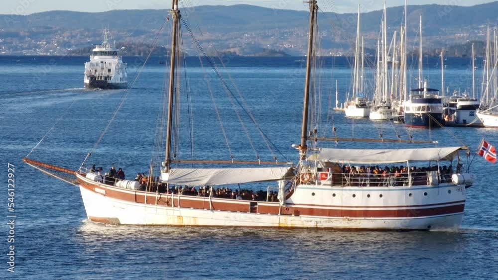 Tourist boat cruising on blue sea water in Oslofjord off Oslo Norway. White wooden sailboat (cruise ship) with two masts and no sails. Tourist boat cruising on blue sea water in Oslofjord off Oslo Norway. White wooden sailboat (cruise ship) with two masts and no sails.