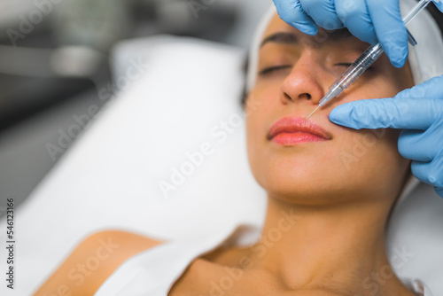 Extreme closeup indoor shot showing lip filler procedure at SPA and wellness salon. A licensed healthcare professional performing dermal filler on her caucasian female patient. High quality photo photo