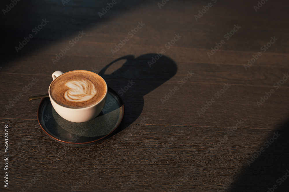A cup of coffee on a wooden table closeup.