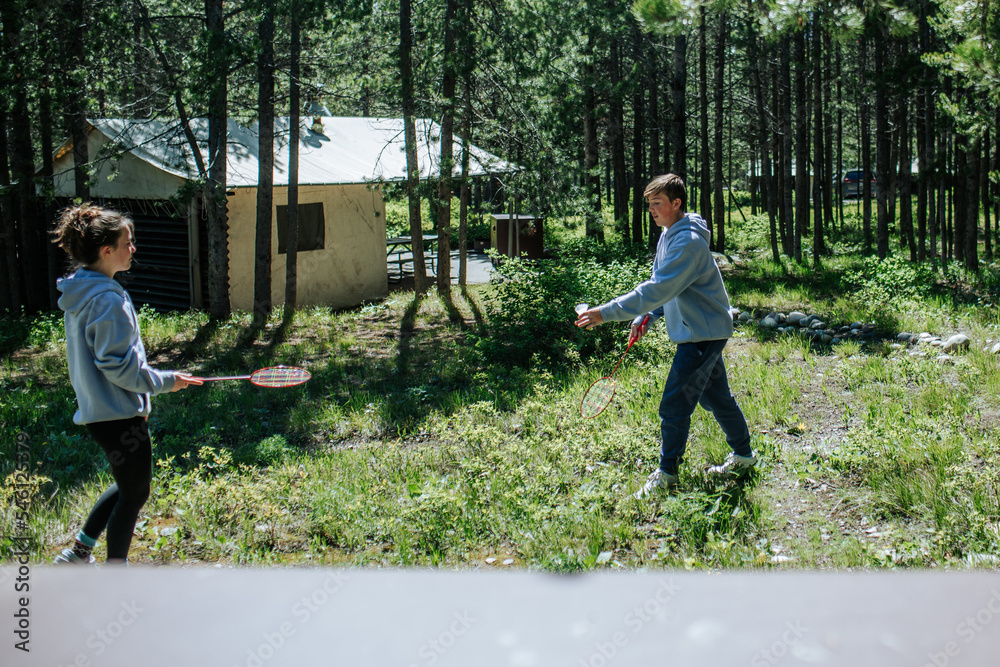 Two teenagers playing badminton outside at campground Stock Photo