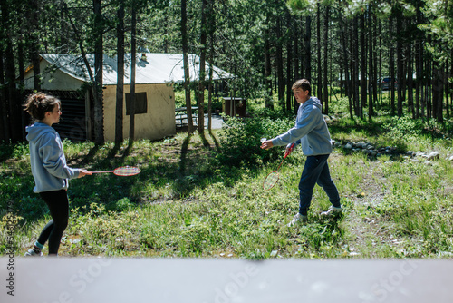 Two teenagers playing badminton outside at campground photo