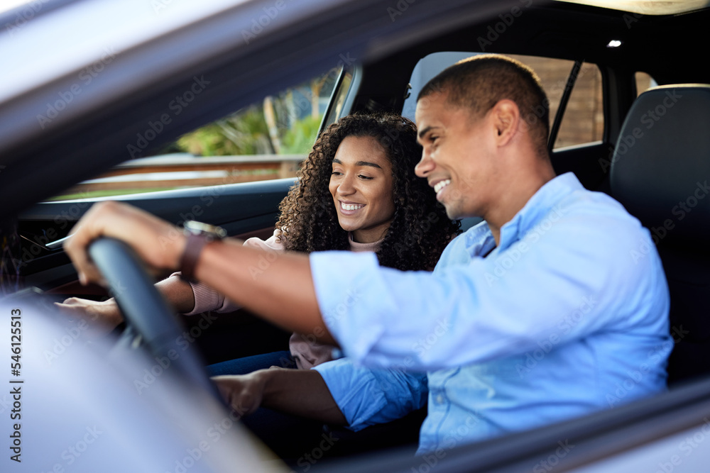 Happy couple using touch screen sitting in car during road trip Happy couple using touch screen sitting in car during road trip