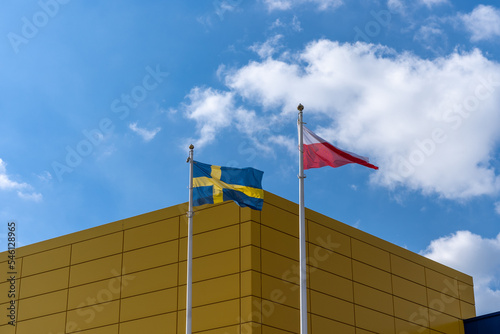 Polish and Swedish flags flying on a high mast
