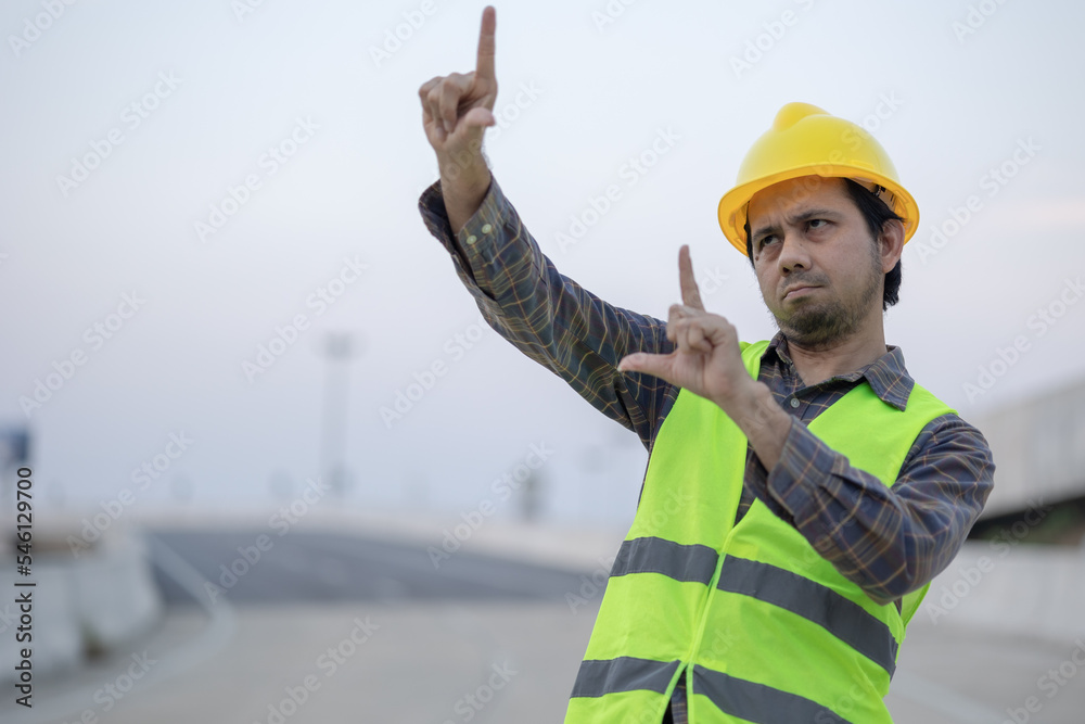 Portrait of Asian male construction worker pointing out the construction drawings. Portrait of Asian male construction worker pointing out the construction drawings.