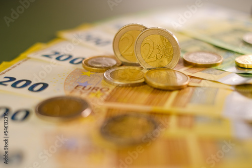  two euro coins and Two hundred euro banknotes .Expenses and incomes in European countries. Finance and savings.Cash payments and expenses.Euro currency. photo