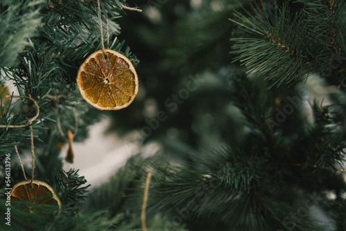 Rustic decorated ornament on Christmas tree with dried orange slices, sustainable Christmas decors concept photo