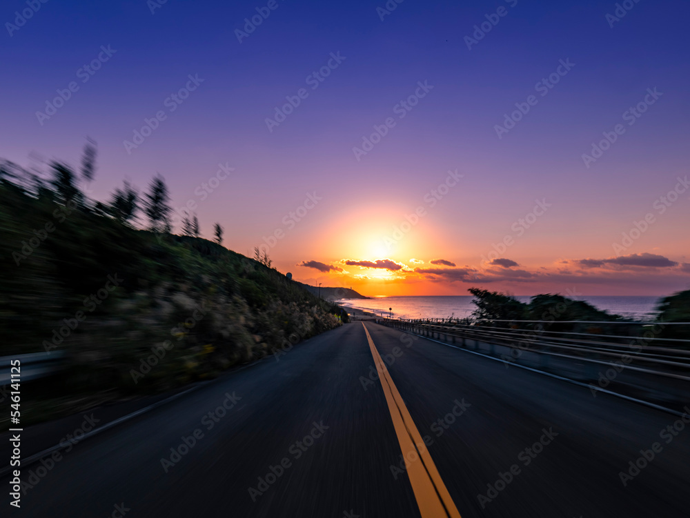 POV shot of driving through the woods and up a slope along the coast at dawn
