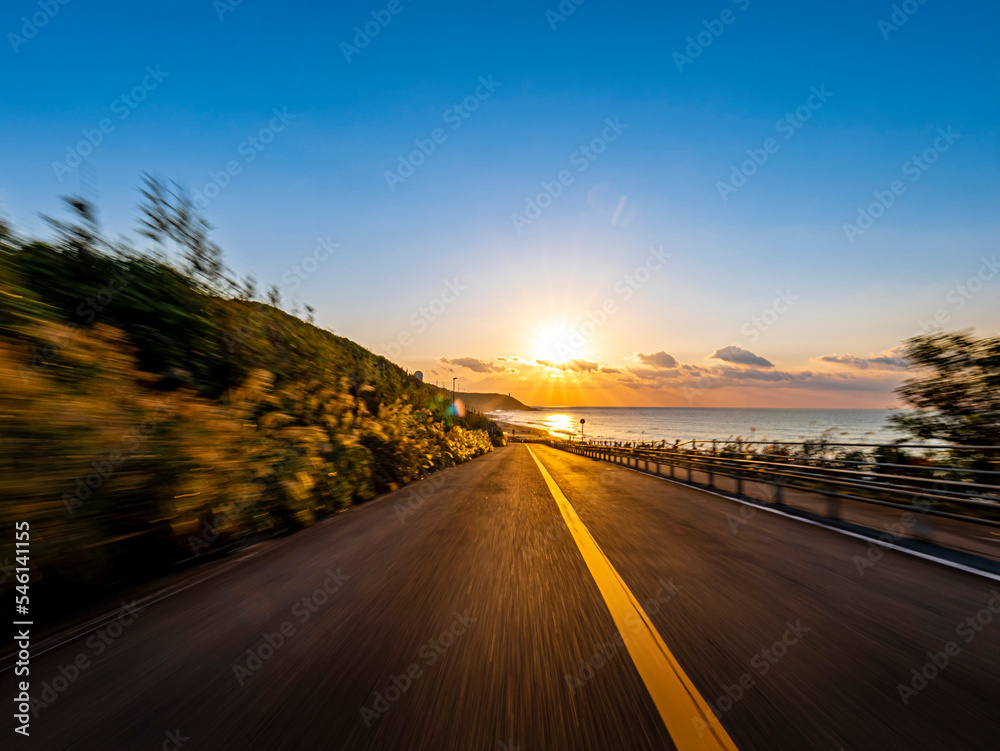 POV shot of driving through the woods and up a slope along the coast at dawn
