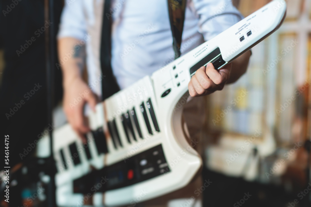 Concert view of a keytar synthesizer player with vocalist and musical jazz  rock band orchestra performing in a background, electronic keyboard  instrument guitar performer on a stage Stock-Foto | Adobe Stock
