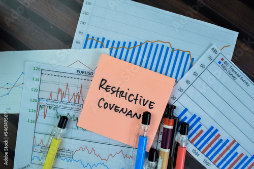 Concept of Restrictive Covenant write on sticky notes isolated on Wooden Table. photo