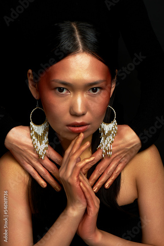 Asian girl, staring. Shamanic motifs, ethnicity. photo