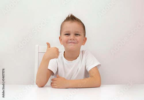 portrait of happy little boy gives thumbs up like beautiful advertisement highlighted on white background. Discount symbol of selected season