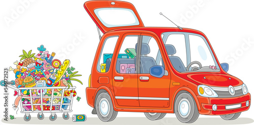 Red small car with an open trunk in a supermarket parking lot and a shopping cart full of foods, drinks, sweets and gifts for winter holidays, vector cartoon illustration isolated on a white backgroun