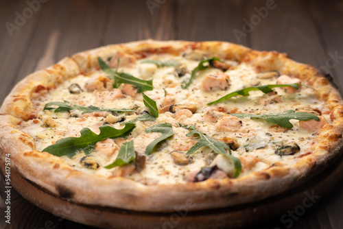 Delicious seafood pizza on wooden table. Pizza menu