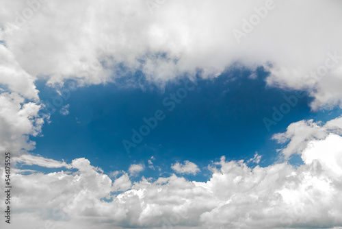 Fototapeta Naklejka Na Ścianę i Meble -  View of a piece of blue oval-shaped sky with white clouds at the edges of the frame, copy space.