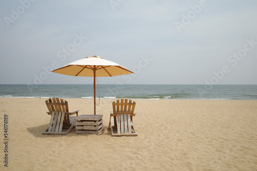 Beach Wooden chairs and a parasol on sand beach for looking sea view .vacation on the beach 