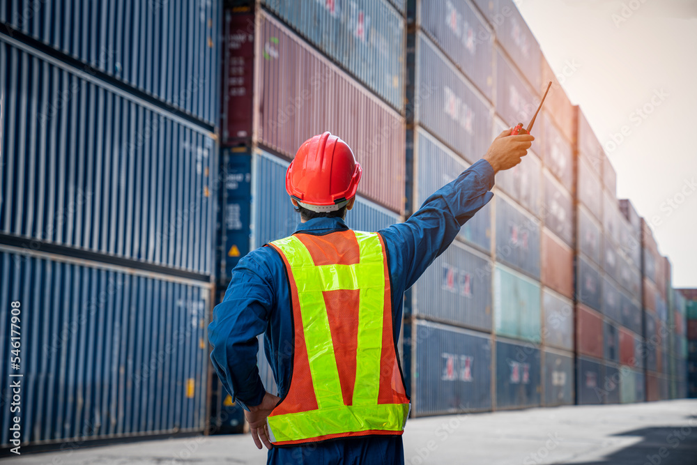 Male Container yard worker control and checking container at container yard warehouse. Logistics business. Import and export concept.