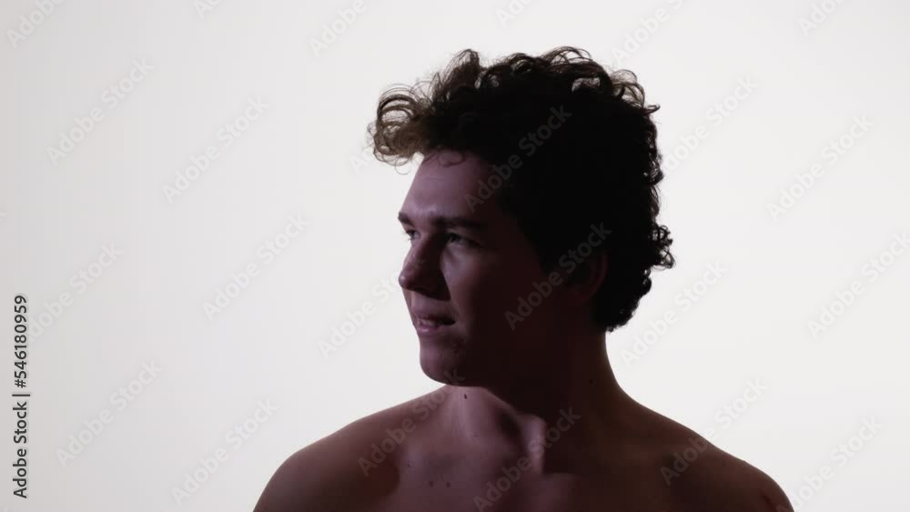 Happy man. Silhouette portrait. Positive mood. Smiling guy with bare shoulder curly hairstyle looking aside posing white background. Happy man. Silhouette portrait. Positive mood. Smiling guy with bare shoulder curly hairstyle looking aside posing white background.