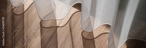 Sunlight falling on wooden floor and creating shadow from curtains background