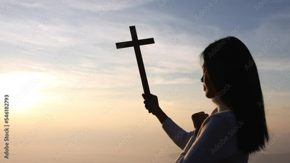 Silhouette of woman praying with cross in nature sunrise background ...