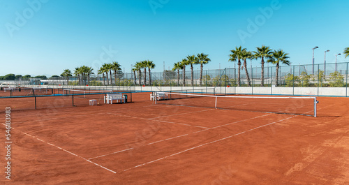 Obraz na plátně Baseline and net of an empty clay tennis court on a sunny day
