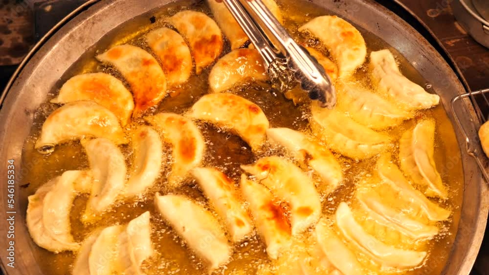 Gyoza dumplings fried in oil at China Town night market, high quality asian street food concept 4K slowmotion footage. Bangkok, Thailand. Gyoza dumplings fried in oil at China Town night market, high quality asian street food concept 4K slowmotion footage. Bangkok, Thailand.