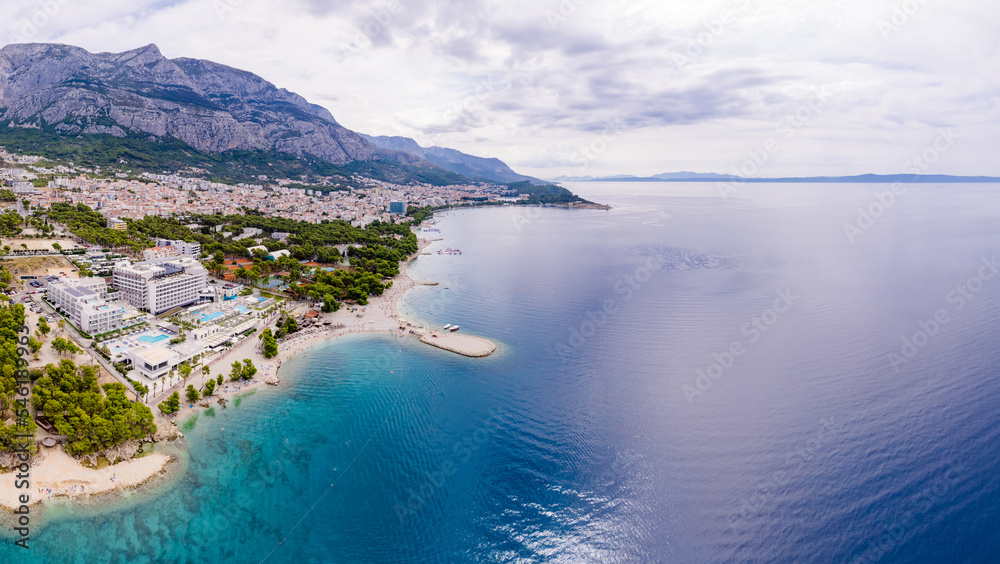 Obraz premium Drone aerial view of Makarska city, Croatia. Sunset over the city, beach and se. Biokovo mountains in the background. Summer time.