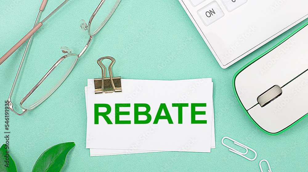 Φωτογραφία On a light green background there is a white calculator, a computer mouse, green leaves of a plant, gold-rimmed glasses and a white card with text REBATE