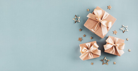 Greeting card for Christmas or birthday party with gift boxes and golden stars on blue turquoise background.