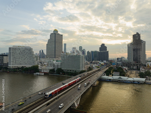 Aerial view of Taksin Bridge and Sathorn Road center of business with transportation over the Chao Phraya River at sunrise scene, Bangkok, Thailand.