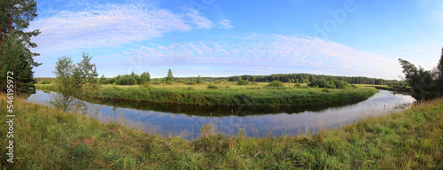 Panorama of calm river with grass on riverside