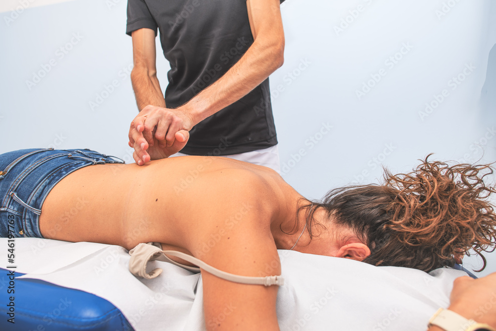 Physiotherapist during a woman's back treatment Physiotherapist during a woman's back treatment