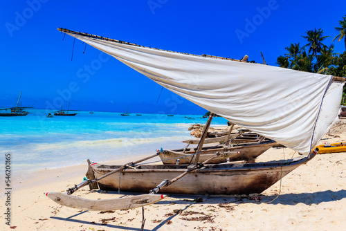 Traditional wooden dhow boats ashore on tropical sandy Nungwi beach in the Indian ocean on Zanzibar, Tanzania