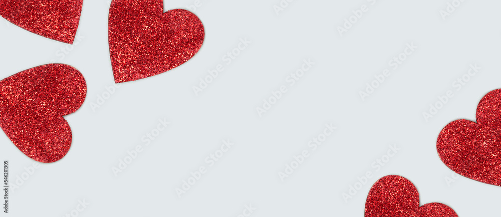 Red glittering hearts with place for text. Festive composition on a blue background. Red glittering hearts with place for text. Festive composition on a blue background.