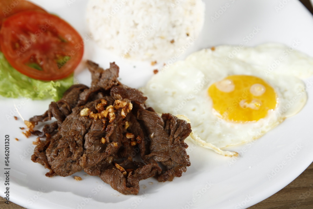 Tapsilog, a Filipino breakfast of beef tapa, fried rice and eggs Stock