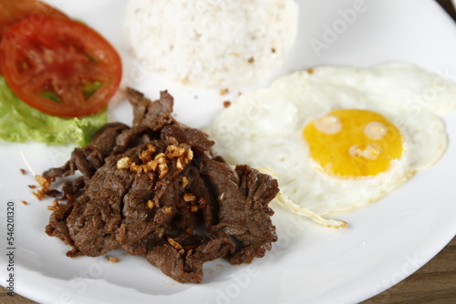Tapsilog, a Filipino breakfast of beef tapa, fried rice and eggs photo