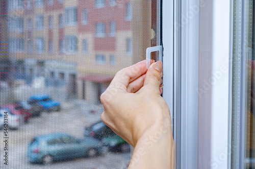 Protection against insects. Mosquito wire screen or mosquito net on a PVC window.