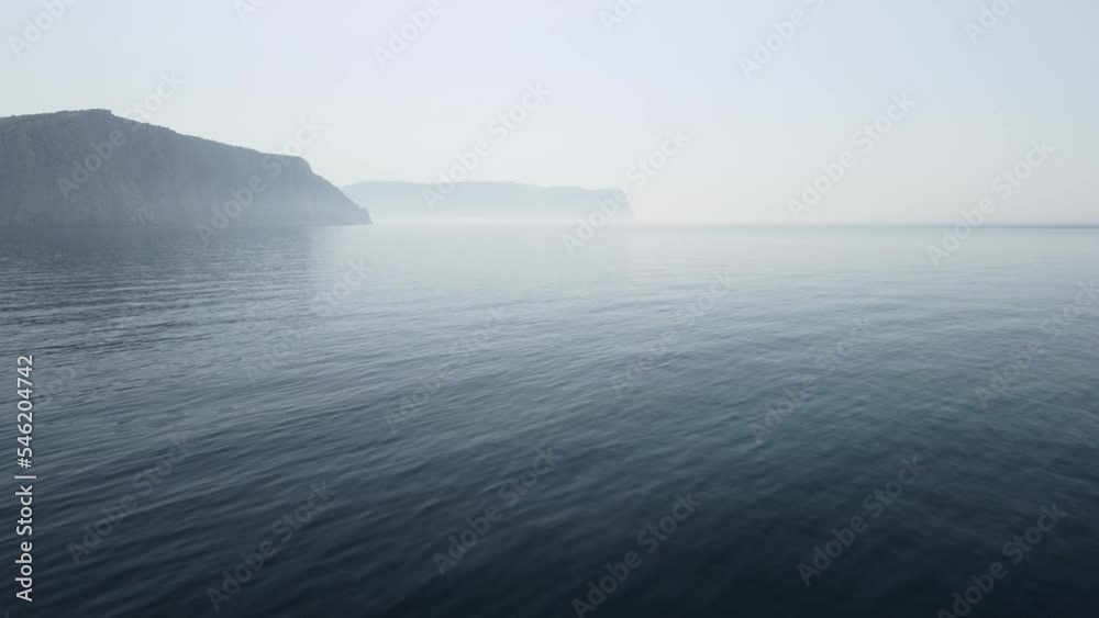 Aerial view from above on calm azure sea and volcanic rocky shores. Small waves on water surface in motion blur. Nature summer ocean sea beach background. Nobody. Holiday, vacation and travel concept Aerial view from above on calm azure sea and volcanic rocky shores. Small waves on water surface in motion blur. Nature summer ocean sea beach background. Nobody. Holiday, vacation and travel concept