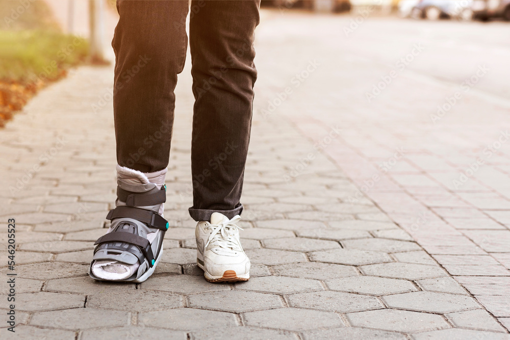 Ankle Orthosis or Brace on Woman Leg walking on Street. Ankle foot orthosis Shoes