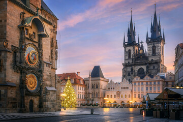 Fototapete Prag Altstädter Ring am frühen Morgen mit astronomischer Uhr im Vordergrund und Teynkirche mit Weihnachtsbaum im Hintergrund in Prag während der Weihnachtszeit.  © Denis Poltoradnev