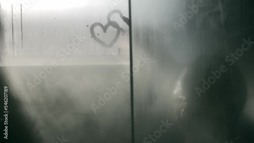 Wallpaper Mural Woman Finger Drawing a Heart Shape on a Wet Window in Shower with Vapor in Switzerland. Torontodigital.ca